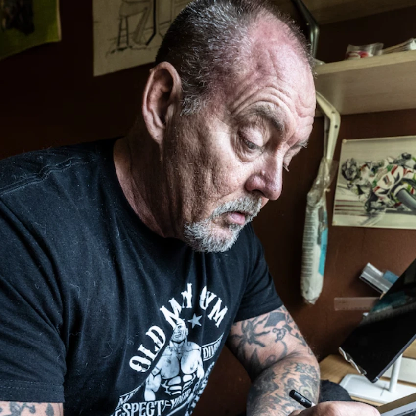 Peter de Weijer aan de tekentafel, werkend aan een tekening