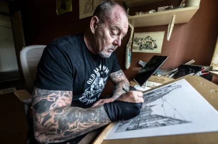 Peter de Weijer aan de tekentafel, werkend aan een tekening